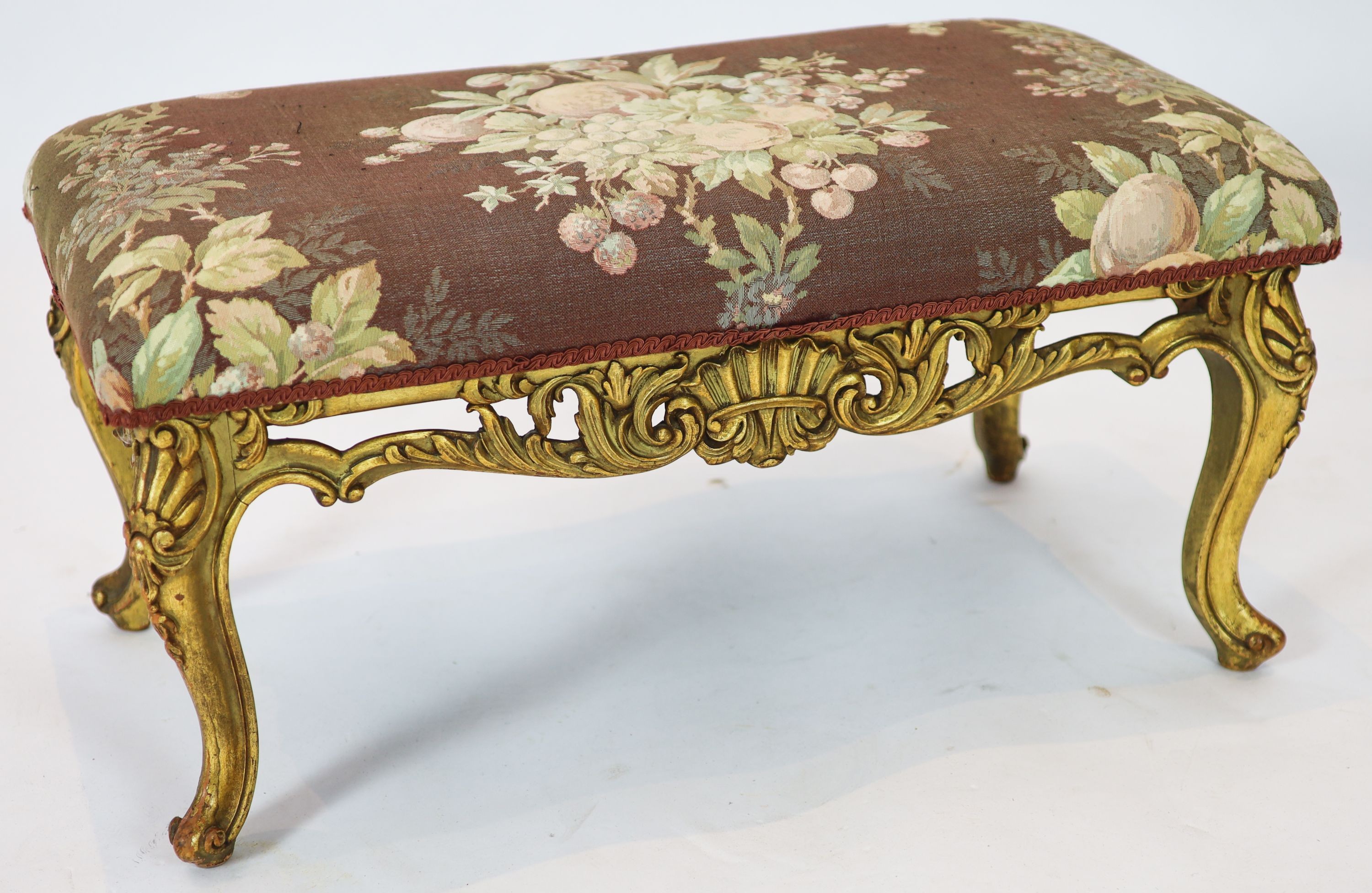 A Louis XV style carved giltwood dressing stool, with a pierced apron, on short cabriole legs, length 84cm, width 45cm, height 42cm